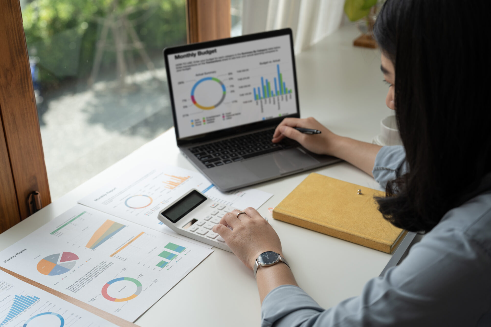 cloud-accounting-lucia-co-cpas-inc-woman-with-paperwork-using-calculator-and-laptop