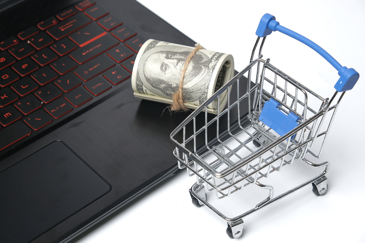 online-shopping-cart-with-money-on-laptop